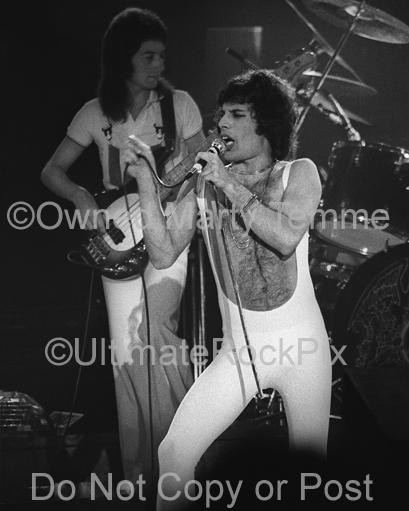 Photo of Freddie Mercury and John Deacon of Queen in concert in 1977 by Marty Temme