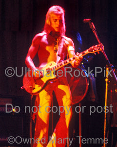 Photo of Mick Ronson of David Bowie in concert in 1973 by Marty Temme