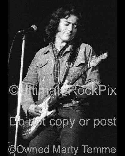 Black and white photo of Rory Gallagher playing his Stratocaster in concert in 1973 by Marty Temme