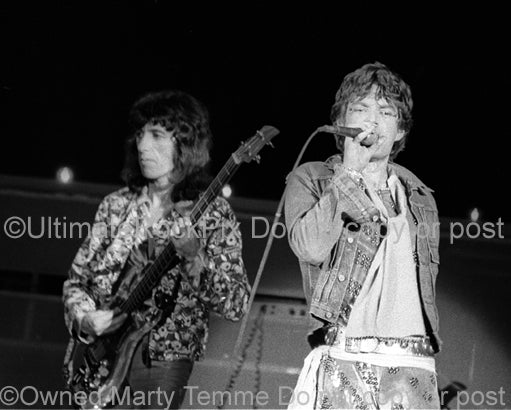 Photo of Bill Wyman and Mick Jagger of The Rolling Stones in concert in 1973 by Marty Temme