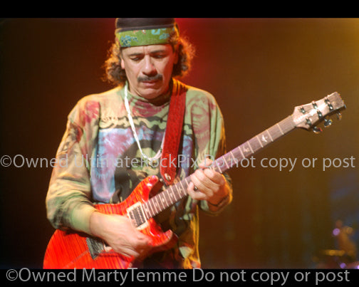 Photo of Carlos Santana of Santana playing a PRS guitar in 1999 by Marty Temme