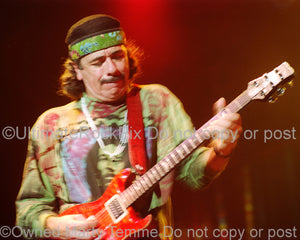 Photo of Carlos Santana of Santana playing a PRS guitar onstage in 1999 by Marty Temme