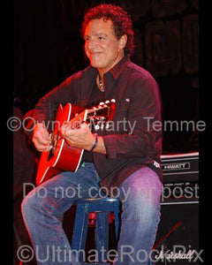 Photos of Neal Schon playing acoustic guitar in 2006 by Marty Temme