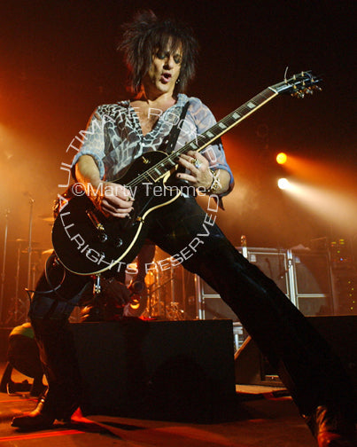 Photo of Steve Stevens playing a Les Paul in concert by Marty Temme