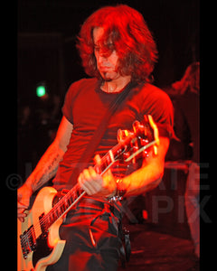 Photo of musician Brian Tichy playing guitar in concert in 2006 by Marty Temme
