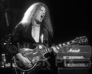 Photo of guitarist John Sykes of Thin Lizzy in concert in 2004 by Marty Temme