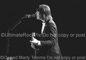 Photo of Todd Rundgren playing acoustic guitar in concert in 1981 by Marty Temme