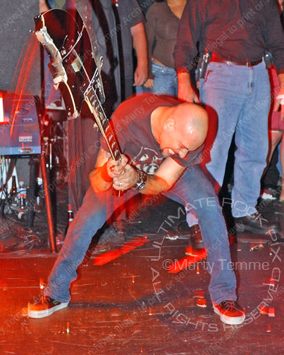 Photo of Dave Kushner of Velvet Revolver smashing his guitar onstage by Marty Temme