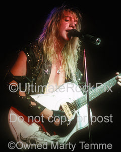 Photo of Jani Lane of Warrant playing guitar in concert by Marty Temme