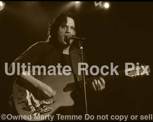 Black and white sepia tint photo of Kip Winger playing acoustic guitar in 2005 by Marty Temme