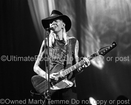 Black and white photo of Johnny Winter playing his Gibson Firebird in concert in 1998