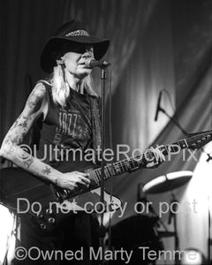 Black and white photo of Johnny Winter playing his Gibson Firebird in concert by Marty Temme