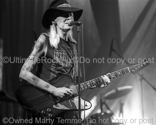 Photo of Johnny Winter playing his Gibson Firebird in concert by Marty Temme