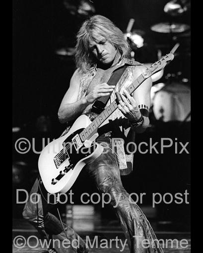 Black and white photo of Doug Aldrich of Whitesnake playing guitar with a slide in concert by Marty Temme