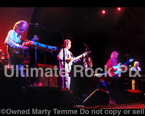 Photo of Steve Howe, Jon Anderson, Chris Squire and Rick Wakeman of Yes in concert in 2003 by Marty Temme