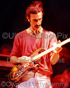 Photo of Frank Zappa playing a Stratocaster given to him by Jimi Hendrix in concert in 1978 by Marty Temme
